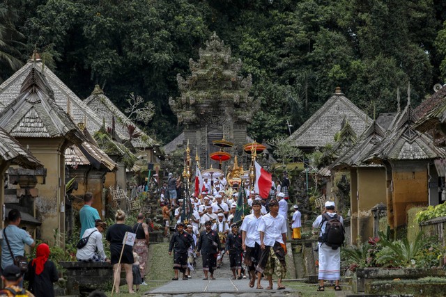 Sejumlah turis menyaksikan umat hindu melaksanakan ibadah di desa Penglipuran, Bangli, Bali, selasa (7/3/2023).  Foto: Aditia Noviansyah/kumparan