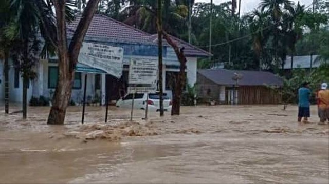 Warga melintasi banjir yang melanda 2 desa di Kabupaten Dharmasraya, Sumatera Barat, Jumat (10/3). Foto: Dok: BPBD Dharmasraya