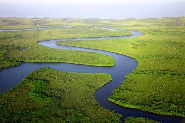 Ilustrasi sedimentasi fluvial yang terjadi di sebuah aliran sungai. Foto: Unsplash/Dan Roizer