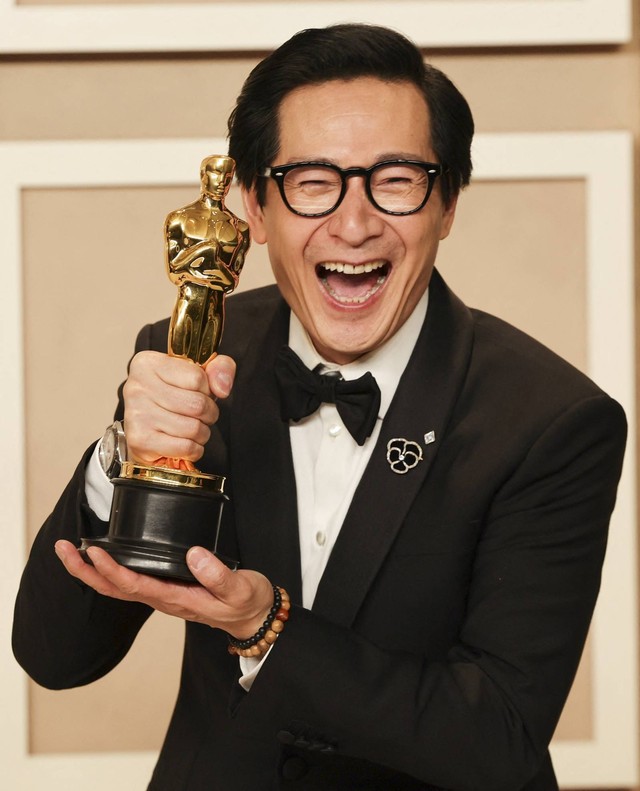 Aktor Pendukung Terbaik Ke Huy Quan berpose dengan Oscar-nya di ruang foto Oscars pada Academy Awards ke-95 di Hollywood, Los Angeles, California, AS, Minggu (12/3/2023). Foto: Mike Blake/REUTERS