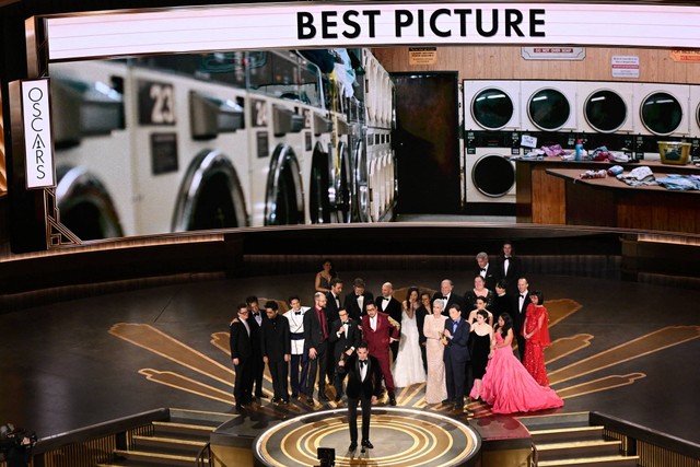 Produser film AS Jonathan Wang (Tengah) menerima Oscar untuk Film Terbaik untuk "Everything Everywhere All at Once" di atas panggung Academy Awards Tahunan ke-95 di Dolby Theatre di Hollywood, California, AS, Minggu (12/3/2023). Foto: Patrick T. Fallon/AFP