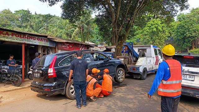 Evakuasi mobil Honda CRV yang sempat nyemplung ke lubang galian proyek di Jalan Margasatwa Raya. Foto: Thomas Bosco/kumparan