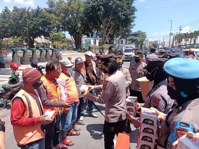 Kapolres Magelang Kota AKBP Yolanda Evalyn Sebayang bagikan masker dan snack untuk pengguna jalan di Magelang usai erupsi Gunung Merapi, Senin (13/3/2023). Foto: Hermanto/Tugu Jogja