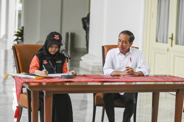 Presiden Joko Widodo (kanan) menyaksikan petugas pemutakhiran data pemilih (Pantarlih) mencocokan dokumen kependudukannya saat proses pencocokan dan penelitian (Coklit) data pemilih untuk Pemilu 2024 di Istana Merdeka, Jakarta, Selasa (14/2/2023). Foto: Hafidz Mubarak A/Antara Foto