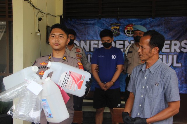 Polisi menunjukkan barang bukti dan pelaku pengoplos minuman keras, Rabu (15/3/2023). Foto: erfanto/Tugu Jogja