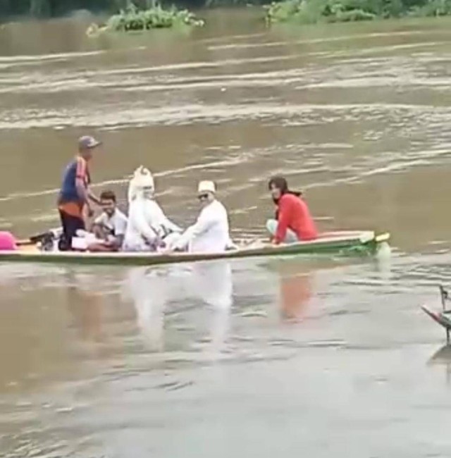 Potongan video sepasang pengantin saat melewati banjir menggunakan perahu, Foto : Istimewa
