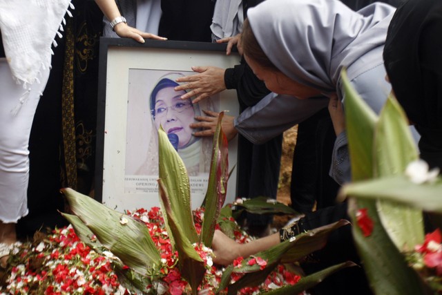 Keluarga memegang foto Nani Wijaya usai pemakaman di TPU Karang Tengah, Babakan Madang, Kabupaten Bogor, Jawa Barat, Kamis (16/3/2023). Foto: Yulius Satria Wijaya/Antara Foto