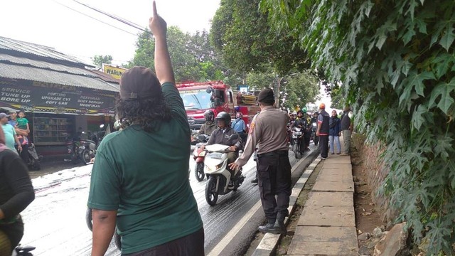 Polisi dan pemadam kebakaran membersihkan tumpahan oli di Jalan Bintaro, Pesanggrahan, Jakarta Selatan, Jumat (17/3/2023). Foto: Dok. Istimewa