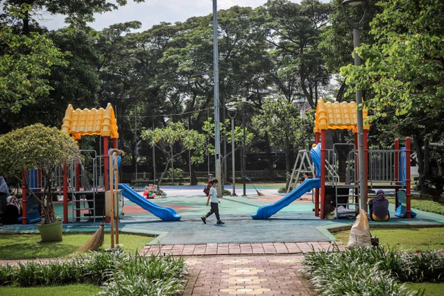 Orang tua menemani anak-anak bermain prosotan di Ruang terbuka hijau (RTH) Taman Menteng, Jakarta Pusat, Sabtu (18/3/2023). Foto: Jamal Ramadhan/kumparan