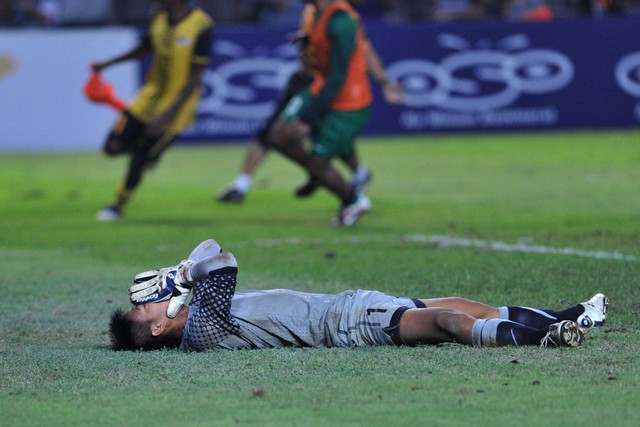 Kurnia Meiga bereaksi usai gawang Timnas Indonesia dijebol pemain Timnas Malaysia, Baddrol Bakhtiar, dalam pertandingan final SEA Games ke-26 di Jakarta pada 21 November 2011. Foto: ADEK BERRY / AFP