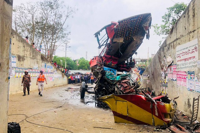 Warga melihat bus yang mengalami kecelakaan di Madaripur, Bangladesh, Minggu (19/3/2023).  Foto: AFP