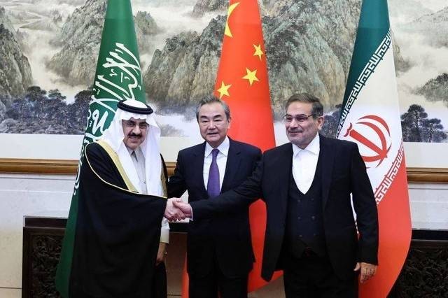 Anggota Biro Politik pada Komite Sentral Partai Komunis China Wang Yi (tengah),  bersama Direktur Komisi Hubungan Luar Negeri Iran Ali Shamkhani dan Penasihat Keamanan Nasional Arab Saudi Musaad bin Mohammed Al Aiban foto bersama.  Foto: China Daily/ via REUTERS