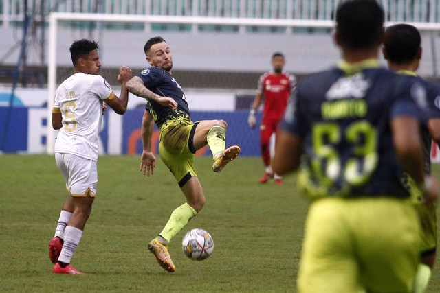 Pemain Persib Bandung Marc Klok (tengah) berebut bola dengan pemain Dewa United Theo Numberi (kiri) dalam lanjutan BRI Liga 1 di Stadion Pakansari, Kabupaten Bogor, Jawa Barat, Senin (20/3/2023).  Foto: Yulius Satria Wijaya/ANTARA FOTO