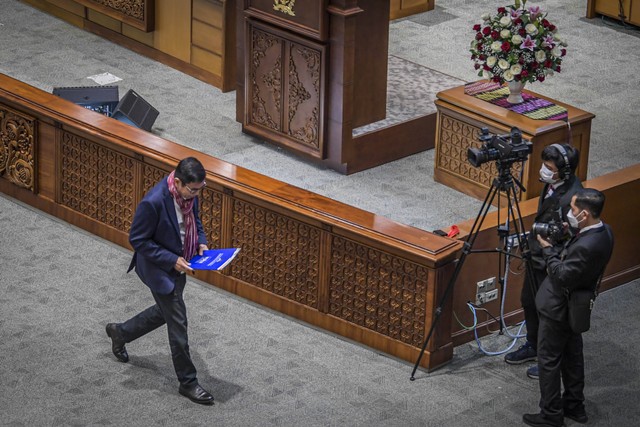 Anggota DPR fraksi Partai Demokrat Hinca Panjaitan (kiri) membawa dokumen keputusan fraksi untuk menolak Perppu Ciptaker disahkan jadi UU dalam Sidang Paripurna DPR ke-19 Masa Persidangan IV Tahun Sidang 2022-2023 di Kompleks Parlemen, Senayan. Foto: Galih Pradipta/Antara Foto