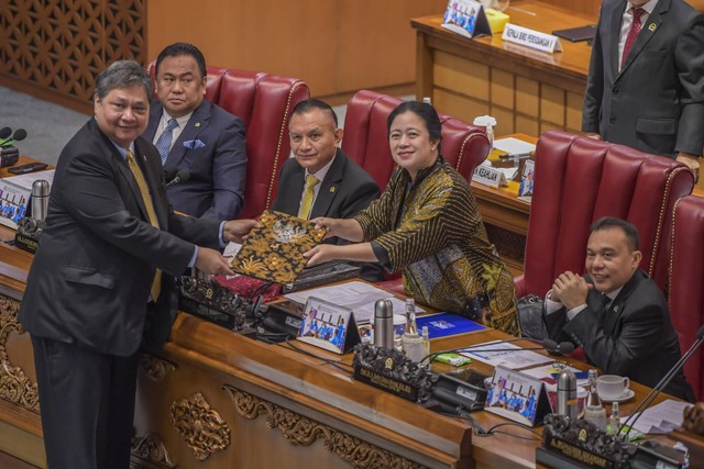 Menteri Koordinator Bidang Perekonomian Airlangga Hartarto (kiri) memberikan dokumen pandangan pemerintah kepada Ketua DPR Puan Maharani (kedua kanan) disaksikan Wakil Ketua DPR Rachmat Gobel (kedua kiri), Lodewijk Freidrich Paulus (tengah). Foto: Galih Pradipta/Antara Foto