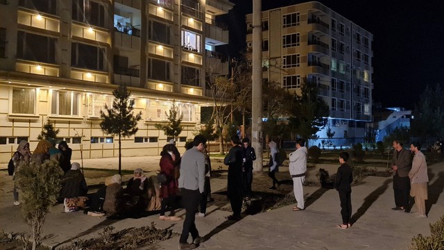 Penduduk Afghanistan berkumpul di bagian bawah gedung apartemen mereka setelah gempa kuat di Kabul pada Selasa (21/3/2023). Foto: STR/AFP