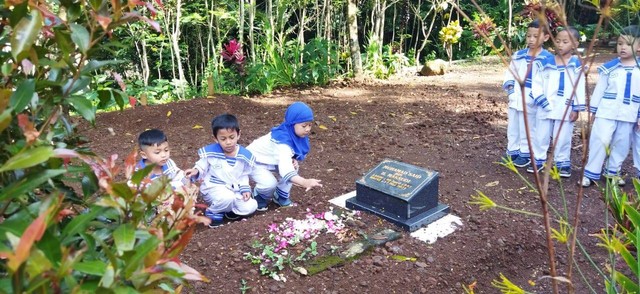 Anak-anak TK Alkautsar sedang menabur bunga di atas pusara makam pendiri yayasan