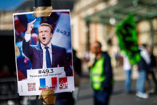 Poster dengan potret Presiden Prancis Emmanuel Macron dan slogan "49.3, karena ini proyek saya" terlihat di dekat stasiun kereta api ketika para pekerja Prancis unjuk rasa. Foto: Eric Gaillard/REUTERS