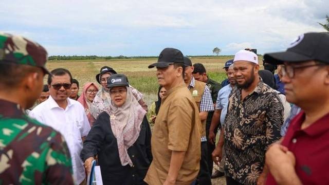 Pj Gubernur Aceh, Achmad Marzuki (tengah) meninjau lokasi sawah yang terdampak banjir Aceh Utara, Selasa (23/10/2022). Foto: Suparta/acehkini