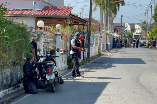 Polisi bersenjata mengambil posisi di jalan dekat lingkungan rumah pria bersenjata di provinsi Phetchaburi, Thailand, Kamis (23/3/2023).  Foto: Supawat Konmun/AP PHOTO