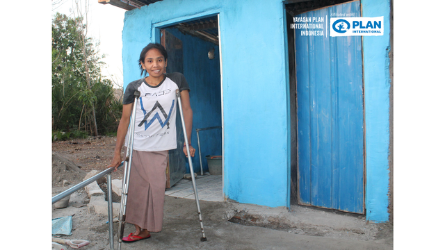 Adriana, Peserta program WINNER Plan Indonesia di depan salah satu fasilitas sanitasi di desanya. Foto: Yayasan Plan International Indonesia