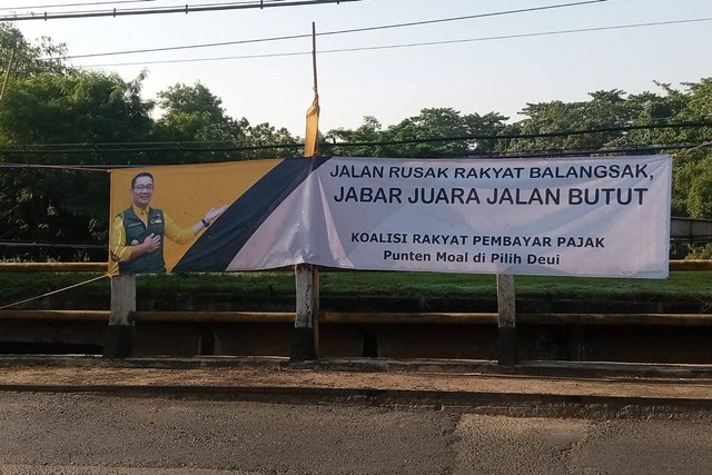 Spanduk bertuliskan "Jabar Juara Jalan Butut" terpasang di Jembatan Sungai Cilamaya, Subang, Jumat (24/3). Foto: Dok. Istimewa