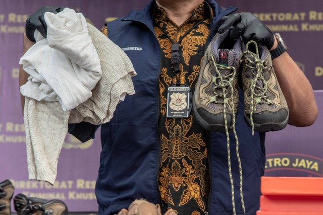 Petugas kepolisian menunjukan barang bukti berupa pakaian bekas hasil pengungkapan kasus penyelundupan barang bekas dan ilegal di Polda Metro Jaya, Jakarta, Jumat (24/3/2023). Foto: Muhammad Adimaja/ANTARA FOTO
