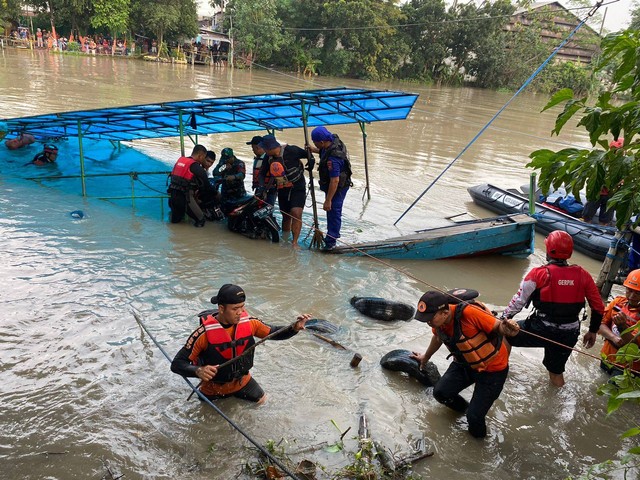 Petugas gabungan dari BPBD, SAR Surabaya, TNI, serta anggota kepolisian mengevakuasi satu korban tewas akibat perahu penyebrangan tenggelam di Sungai Brantas Jalan Raya Mastrip Kemlaten, Surabaya. Foto: Dok. Istimewa