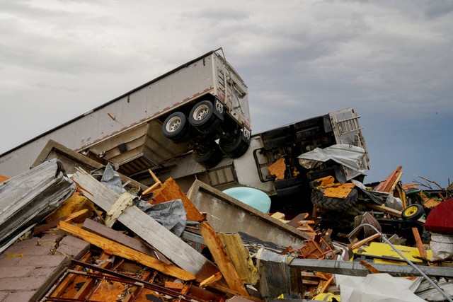 Truk-truk semi terlihat menumpuk di atas satu sama lain setelah badai petir yang menimbulkan tornado yang merobek negara bagian di Rolling Fork, Mississippi, AS, Minggu (26/3/2023). Foto: Cheney Orr/REUTERS