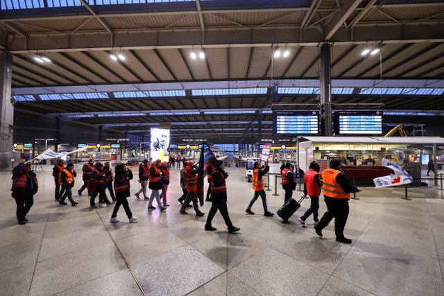 Para pekerja memprotes di stasiun kereta api utama Munich selama pemogokan nasional yang diserukan oleh serikat buruh Jerman Verdi atas sengketa upah di Munich, Jerman, Senin (27/3/2023).  Foto: Lukas Barth/REUTERS