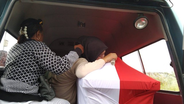 Tampak kakak perempuan dari almarhum Serda Riswar Ramli Mansamber menangis diatas peti jenazah adiknya yang menjadi korban penembakan OTK di Kabupaten Puncak Jaya, foto: Yanti/BalleoNEWS