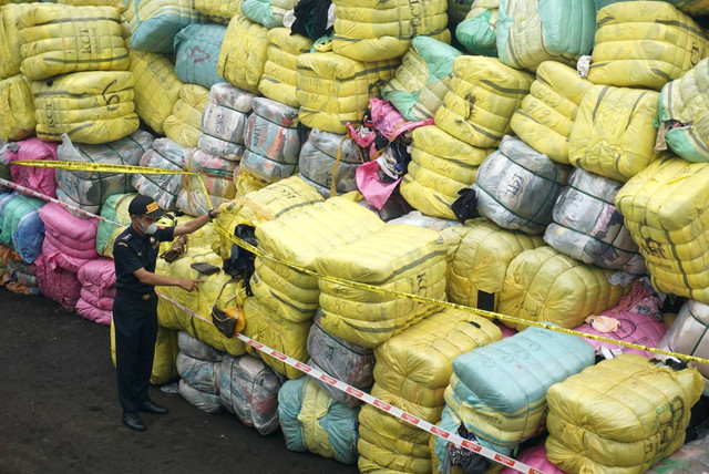 Petugas mengecek barang bekas impor ilegal sitaan di Tempat Penimbunan Pabean (TPP) DJBC, Bekasi, Selasa (28/3/2023). Foto: Iqbal Firdaus/kumparan