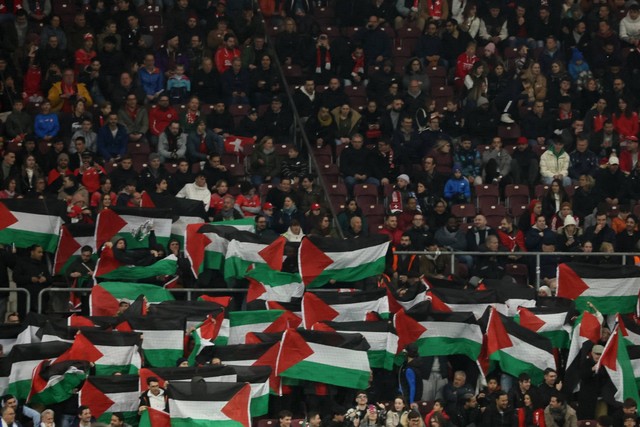 Fans mengibarkan bendera Palestina selama pertandingan Swiss vs Israel pada Kualifikasi UEFA Euro 2024 di Stade de Geneve, Lancy, Swiss,  Selas (28/3/2023). Foto: Denis Balibouse/REUTERS