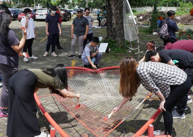 Mahasiswi PCU sedang menyiapkan rangka untuk spot foto di Dusun Tlocor.