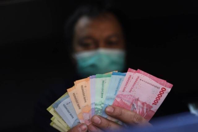 Warga menunjukkan uang rupiah kertas Tahun Emisi 2022 di Pasar Senen, Jakarta Pusat, Senin (29/8/2022). Foto: Iqbal Firdaus/kumparan