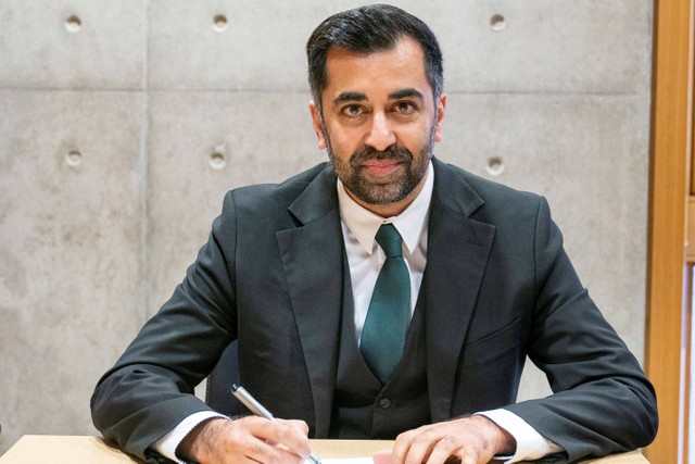 Pemimpin Partai Nasional Skotlandia (SNP) yang baru terpilih, Humza Yousaf (tengah), menandatangani formulir pencalonan untuk menjadi Menteri Pertama Skotlandia di Edinburgh. Foto: Jane Barlow / POOL / AFP