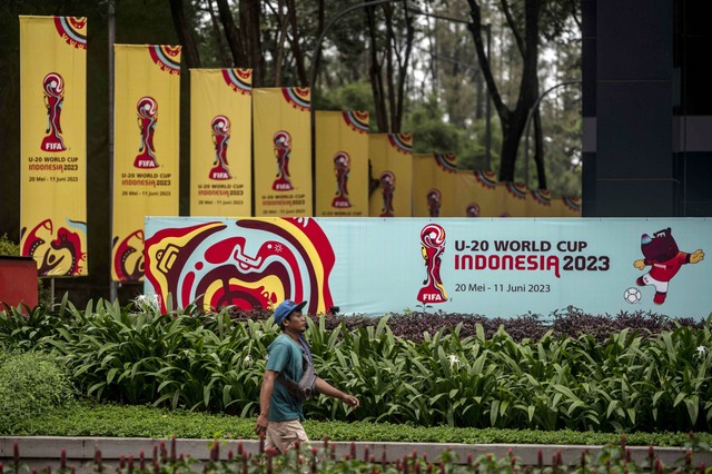 Warga berjalan di dekat papan promosi Piala Dunia U-20 Indonesia 2023 di kawasan GBK Arena, Jakarta, Kamis (30/3/2023). Foto: Aprillio Akbar/Antara Foto