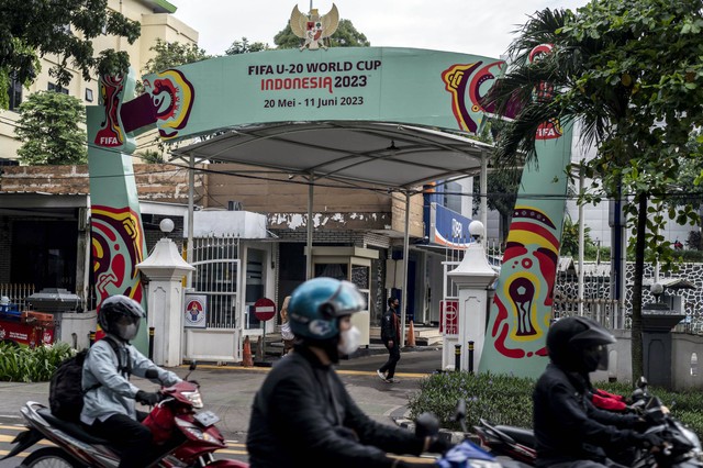 Sepeda motor melintas di dekat papan promosi Piala Dunia U-20 Indonesia 2023 di kawasan Kantor Kemenpora, Jakarta, Kamis (30/3/2023). Foto: Aprillio Akbar/Antara Foto
