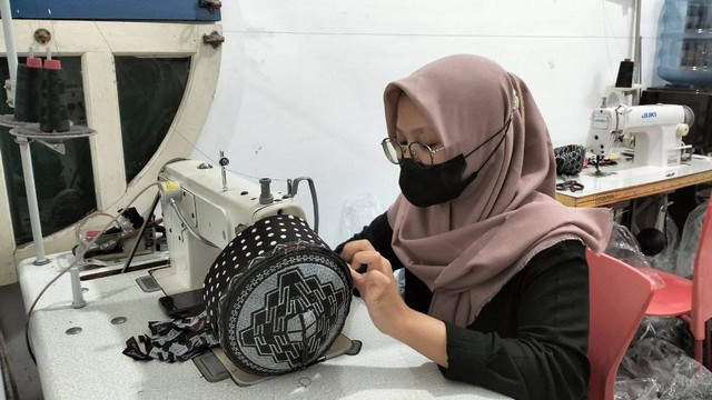 Seorang pekerja tengah menjahit peci batik. Foto: Maria Wulan/Tugu Jogja