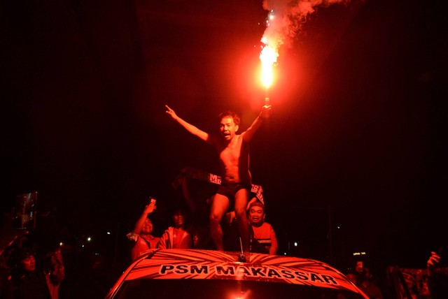 Suporter PSM Makassar menyalakan flare usai nonton bareng pertandingan BRI Liga 1 antara PSM Makassar melawan Madura United di Makassar, Sulawesi Selatan, Jumat (31/3/2023). Foto: ANTARA FOTO/Abriawan Abhe