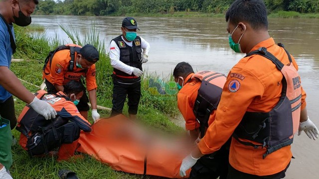 Petugas saat mengevakuasi mayat Nurul Setyo Ningrum (31) warga Kabupaten Ngawi, yang tenggelam di Sungai Bengawan Solo. (Foto: Dok Istimewa)
