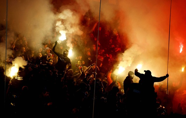 Penggemar Paris Saint-Germain menyalakan suar di tribun sebelum pertandingan di Parc des Princes, Paris, Prancis. Foto: Sarah Meyssonnier/Reuters