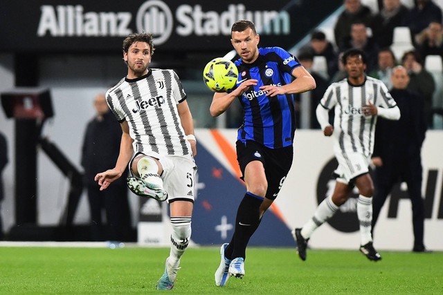 Pemain Juventus Manuel Locatelli berebut bola dengan pemain Inter Milan Edin Dzeko pada pertandingan leg pertama semifinal Coppa Italia di Stadion Allianz Stadium, Turin, Italia, Rabu (5/4/2023).  Foto: Massimo Pinca/REUTERS