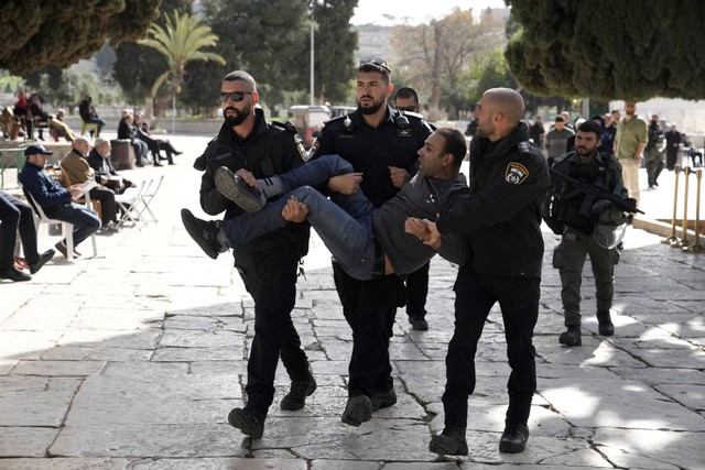 Polisi Israel menangkap pria Palestina di kompleks Masjid Al-Aqsa setelah penggerebekan di situs di Kota Tua Yerusalem selama bulan suci Ramadhan, Rabu (5/4/2023). Foto: Mahmoud Illean/AP Photo