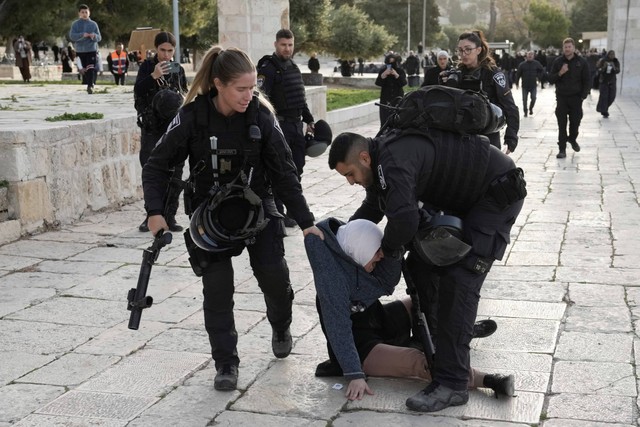 Polisi Israel menangkap warga Palestina di kompleks Masjid Al-Aqsa setelah penggerebekan di situs di Kota Tua Yerusalem selama bulan suci Ramadhan, Rabu (5/4/2023). Foto: Mahmoud Illean/AP Photo