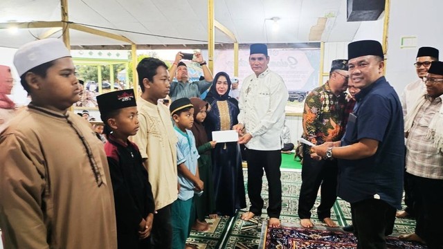Pj Bupati Kobar Anang Dirjo menyerahkan uang santunan untuk anak yatim piatu di Ponpes Miftahul Ulum Paring Kuning. Foto: Lukman Hakim/InfoPBUN