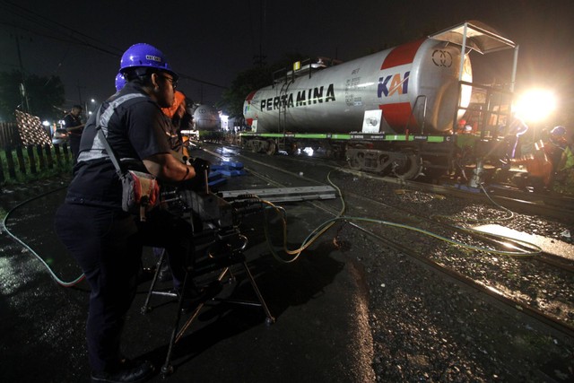 Petugas mengevakuasi rangkaian gerbong kereta api (KA) ketel atau pengangkut BBM yang anjlok di pelintasan Jalan Raya Bebekan, Sepanjang Taman, Sidoarjo, Jawa Timur, Sabtu (8/4/2023). Foto: Umarul Faruq/ANTARA FOTO