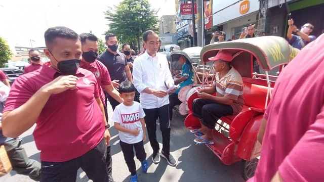 Presiden Jokowi bersama Ibu Iriana Jokowi ajak Jan Ethes membagikan bantuan kepada warga dan pedagang di tiga pasar tradisional di Kota Solo, Jawa Tengah, Minggu (9/4).  Foto: Dok. Istimewa