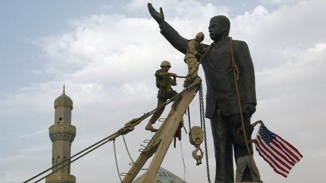 Tentara AS menjatuhkan patung Saddam Hussein.