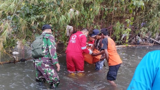 Petugas mengevakuasi mayat bayi yang ditemukan warga di Dam Sungai Bedok Banyon, Sewon, Bantul, Minggu (9/4). Foto: Polres Bantul